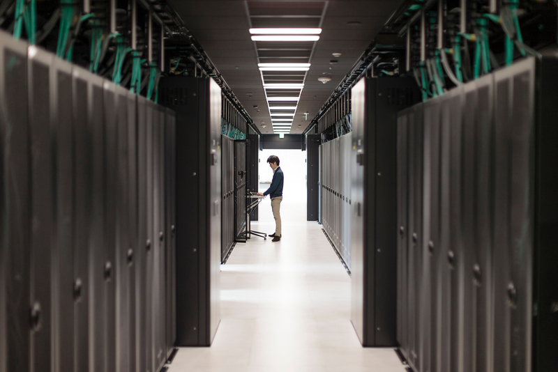 man typing on computer near HPE Servers in server room